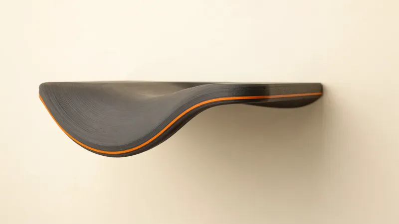 Illustration: a graphite printed shelf-like overhang with a drooping, wavy underside and one orange layer line along the edge