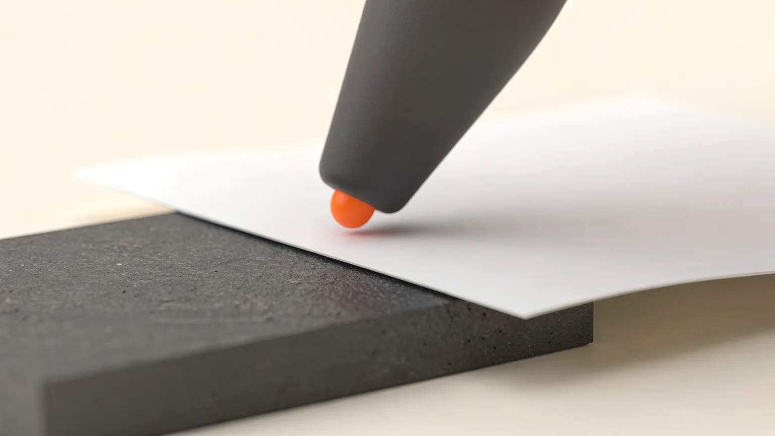 Illustration: a generic nozzle hovering just above a graphite bed with a thin sheet of paper slid between them and an orange spot on the nozzle tip