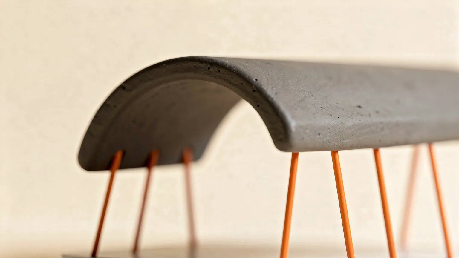 Illustration: a small graphite overhanging arch printed with thin orange support struts underneath holding it up, macro view
