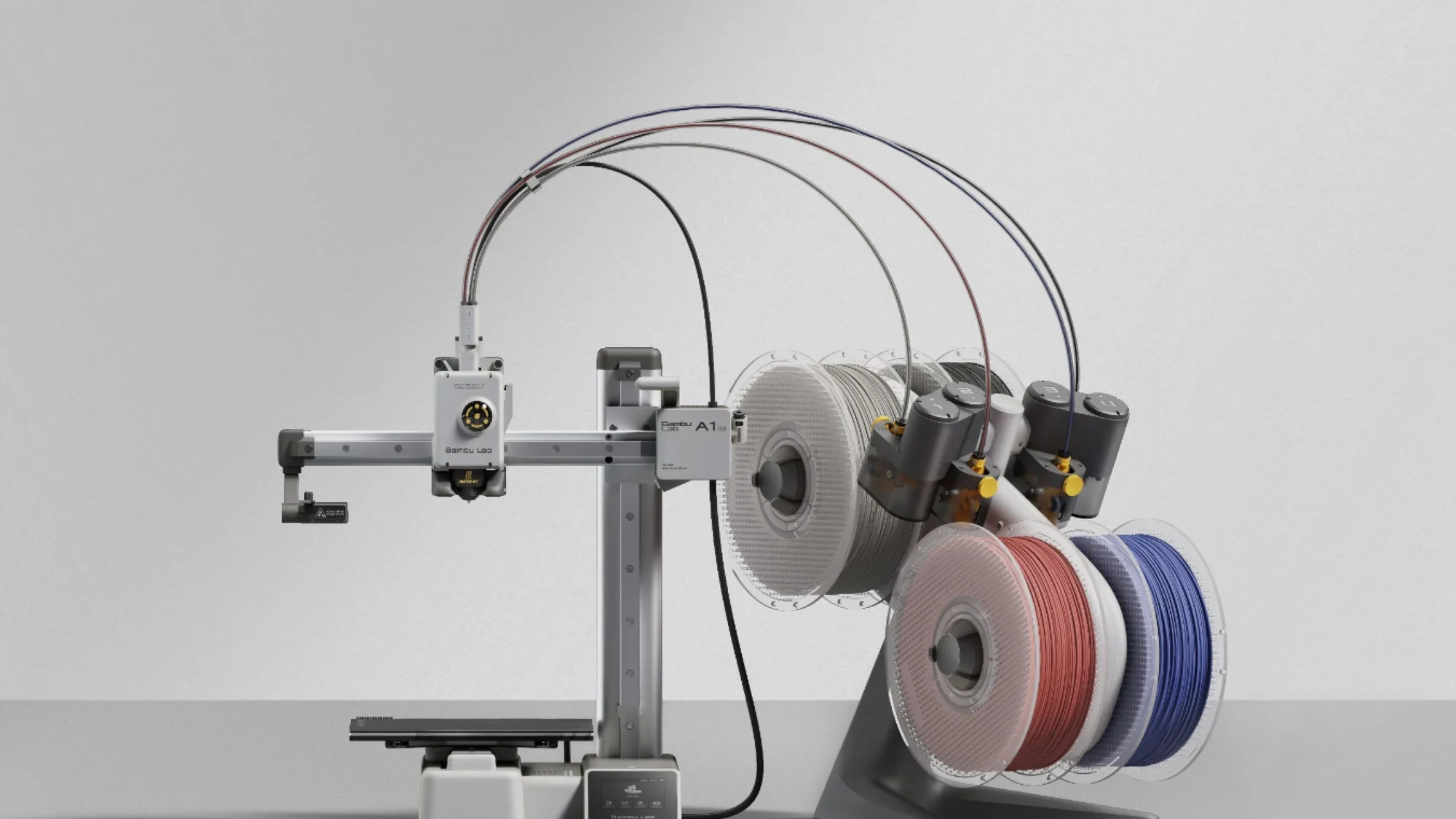 Bambu Lab A1 mini compact 3D printer with AMS lite and four spools of coloured filament on a plain light grey studio background