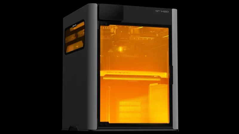 Bambu Lab H2D enclosed 3D printer on a black background with its glass chamber glowing orange and the H2D name on the corner