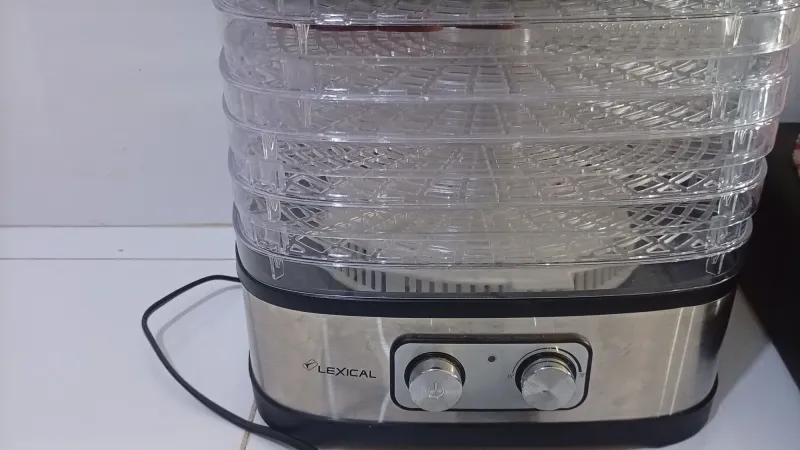 A stacked tray food dehydrator with dial controls on a white worktop